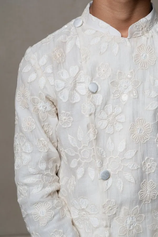 Intricately embroidered off-white bandhgala with matching white kurta and pants for an elegant traditional look