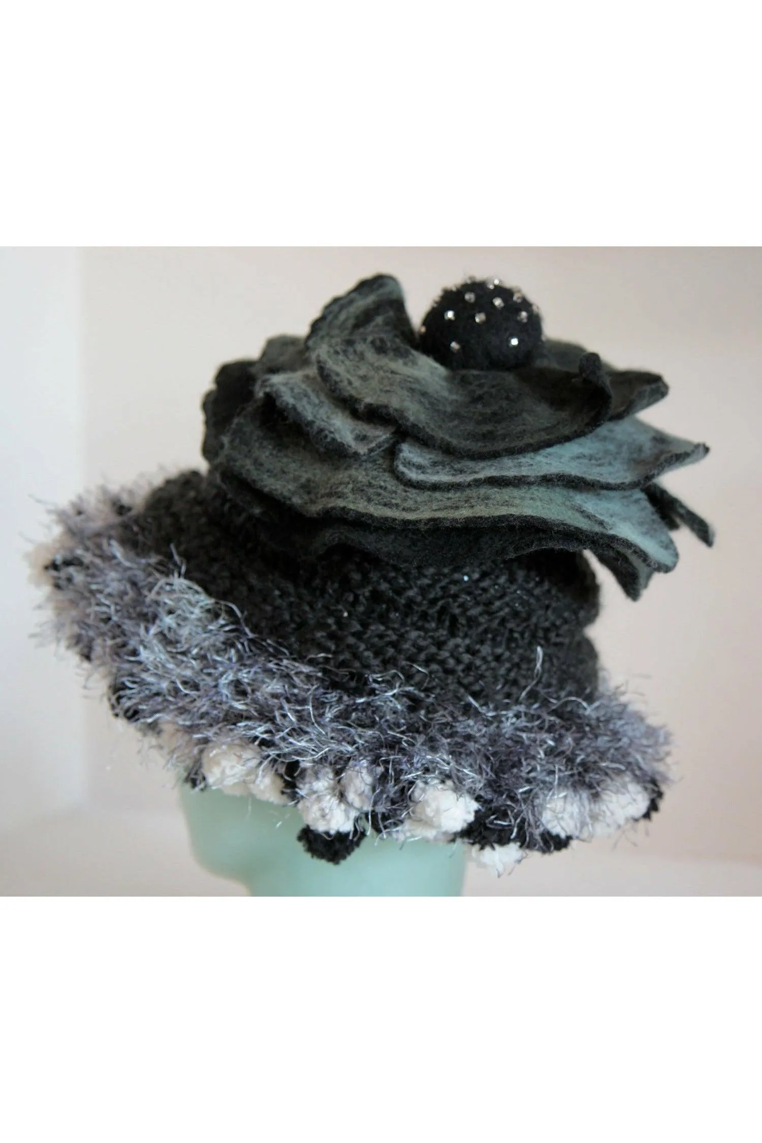 Whimsical black with white and gray hand knit and felt flower hat.